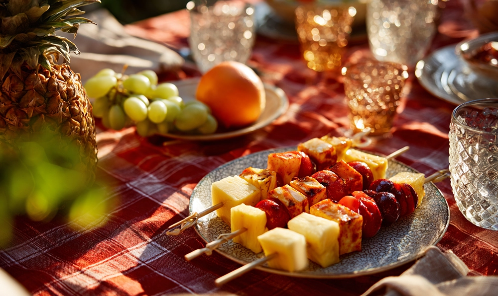 Brochettes de fruits colorées sur une table estivale, ananas, kiwi et pommes