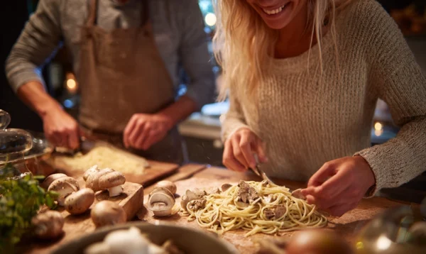 Lucie et Max cuisinant des linguine au blé entier dans une cuisine lumineuse et conviviale