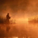 PĂȘcheur attrapant un black bass sur un lac au lever du soleil