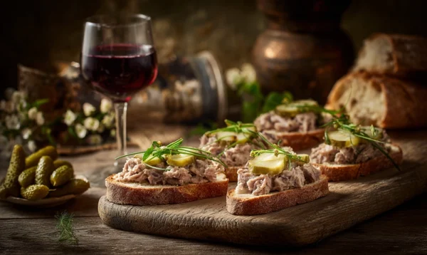 Tartine de pâté de campagne avec cornichons et vin rouge