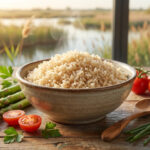 Bol de riz semi-complet fumant, asperges, tomates cerises et herbes sur table en bois devant paysage naturel.