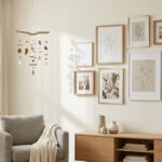 Un salon lumineux avec un mobile suspendu en bois et un mur composé de cadres photos variés au-dessus d'un meuble en bois.